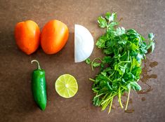 some vegetables are laying out on a table top next to limes and an eggplant