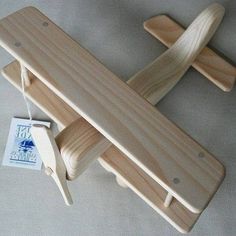 a wooden toy airplane is sitting on the floor