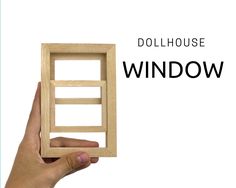 the dollhouse window is made out of wood and holds it in one hand, while the