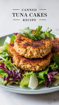 two crab cakes stacked on top of each other with lettuce and carrots