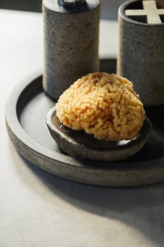 two salt and pepper shakers sitting on a plate with some food in the middle