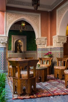 an ornately decorated room with wooden chairs and tables