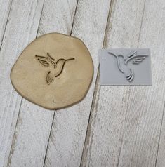 a bird is carved into a stone next to a rubber stamp that says humming on it