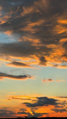 an airplane is flying in the sky at sunset or dawn with some clouds above it