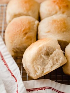 several rolls on a cooling rack with one cut in half and the other partially eaten