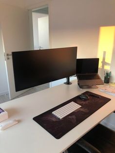 a desk with a laptop, monitor and keyboard on it