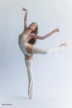 a woman in white tights is doing a ballet move with her legs spread out