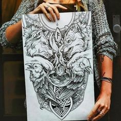 a woman holding up a piece of paper with an image of two wolfs on it