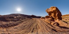 the sun shines brightly in the sky over an arid area with rocks and sand