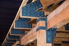 the metal brackets are attached to the wooden beam in this building's interior structure