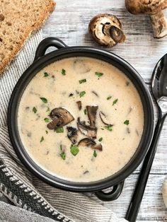 a bowl of soup with mushrooms and bread