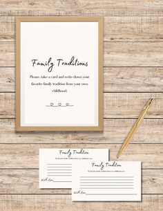 the wedding stationery is set up on a wooden table with a pen and paper