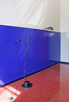 a blue and red wall with a lamp on it's side next to a floor