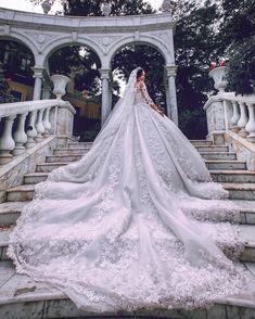 a woman in a wedding dress standing on some steps