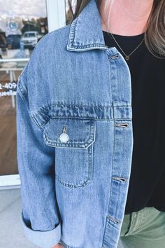 Oversized, denim, trucker jacket. This boxy silhouette is perfect for layering and legging styles. Silver metal buttons line the front and are featured on the pockets. Traditional and timeless collared neckline and yoke across the back. Light/medium wash jean material that is slightly weighted but soft and stretchy. We recommend sizing down if you're traditionally between sizes. - 100% cotton Jean Material, Denim Trucker Jacket, Back Light, Jeans Material, Medium Wash Jeans, Trucker Jacket, Washed Jeans, Metal Buttons, Sweater Coats