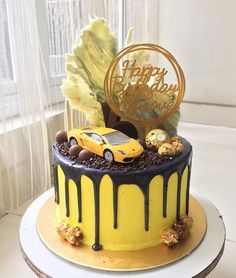 a yellow and black birthday cake with a car on top