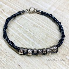 a black leather bracelet with silver beads