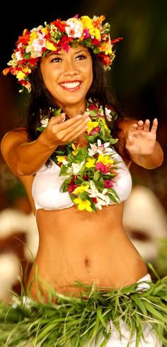 a woman wearing a hula skirt and flowers on her head