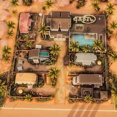 an aerial view of a motel with cars parked in the parking lot and palm trees surrounding it