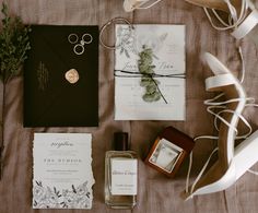 the wedding stationery is laid out on the bed