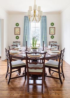 a dinning room table with chairs and a chandelier hanging from the ceiling