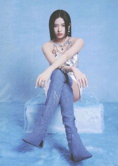 a woman sitting on top of a stool wearing boots