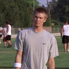 a man holding a tennis racquet on top of a field