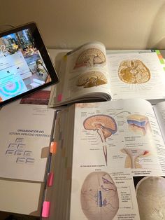 an open book with medical diagrams on it and a cell phone next to the opened book