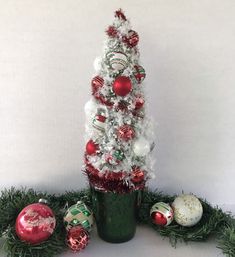 a white christmas tree with red and green ornaments