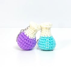 two small crocheted vases sitting next to each other on a white surface