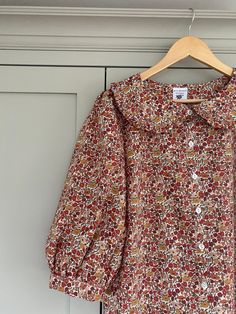 "Hand made Liberty of London floral print Tana Lawn Peter Pan ruffle collar blouse with 3/4 sleeves. *Loose fitting blouse in beautiful liberty print cotton fabric with a ruffle collar and button through front.  *Full 3/4 sleeves have pretty gathers at the sleeve head and cuff.  *Bust darts * Liberty Tana lawn is a luxurious, fine cotton fabric with a silky handle. It is very soft and comfortable to wear. Made to order by me in my studio in East Sussex. Please check my shop announcement for curr Liberty Print Blouse, Classy Tops, Peter Pan Blouse, Peter Pan Collar Top, Blouse With Collar, Ruffle Collar Blouse, Peter Pan Collar Blouse, Peter Pan Collars, Mama Style