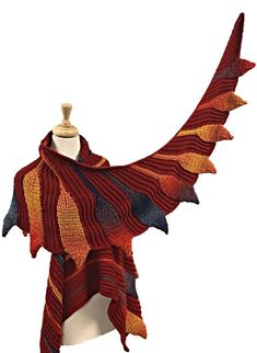 a knitted shawl on a mannequin's head, with an orange and black pattern