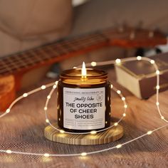 a candle that is sitting on top of a table next to a guitar and some string lights