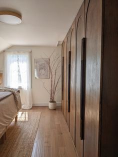 a bedroom with wood floors and white walls