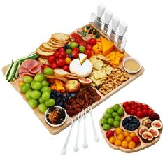 an assortment of fruits and cheeses on a tray with utensils