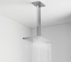 a shower head with water flowing from it's side in a white walled bathroom