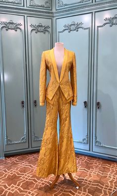 This silk blazer pantsuit is from Wes Gordon's Fall 2003 Runway. The color is a stunning canary yellow with a silver lurex brocade design all through out. The blazer includes a double layer made of yellow silk satin and a high waist flared pant leg. Truly Magnificent. Wes Gordon interned with Oscar De La Renta and Tom Ford after graduating from Central St. Martins in 2009, the same year he launched his own self named line of women's wear. In 2018, he took over at Carolina Herrera as creative director. Blazer and Pant size: 6 Elegant Fitted Yellow Pantsuit, Fitted Yellow Suits For Parties, Fitted Yellow Party Suits, Brocade Blazer Women, Elegant Yellow Pantsuit For Formal Occasions, Elegant Formal Pantsuit For Festive Occasions, Elegant Festive Pantsuit For Formal Occasions, Yellow Long Sleeve Party Set, Yellow Notch Lapel Elegant Suit