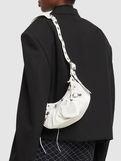 Find BALENCIAGA Le Cagole Leather Shoulder Bag on Editorialist. The Le Cagole shoulder bag is crafted from white leather and features a buckle, silver tone hardware, a zip closure, an adjustable shoulder strap, and a detachable leather tag. The bag measures 14cm in height, 25cm in width, and 6cm in depth. The strap drop can be adjusted to a minimum of 22cm and a maximum of 52.5cm. This bag can be worn on the shoulder or crossbody. It includes a zip pouch. Balenciaga Women, Leather Tag, Zip Pouch, Swim Accessories, Heeled Loafers, Shearling Jacket, Ski Wear, Swimwear Tops, Cloth Bags