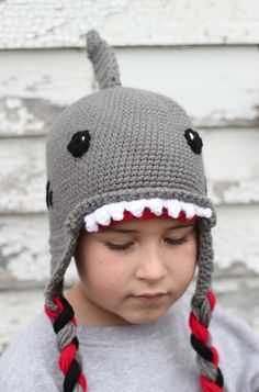 a young boy wearing a crocheted shark hat