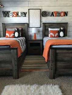 two twin beds with orange and gray bedding in a boys's bedroom area