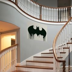 the batman symbol is on the wall next to the stairs in this home's entryway