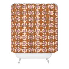 a shower curtain with an orange and pink flower pattern on the outside, in front of a white bathtub