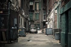 an alley way with trash cans and garbage cans