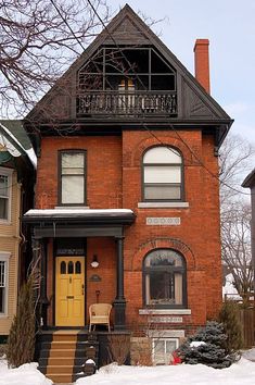 a red brick house with snow on the ground and steps leading up to it's front door