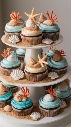 three tiered cupcake display with seashells and starfish on it's sides