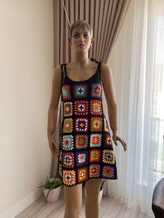 a mannequin wearing a crocheted dress in front of a window