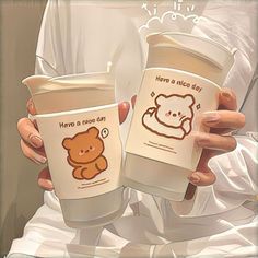 two people holding up coffee cups with bears on them