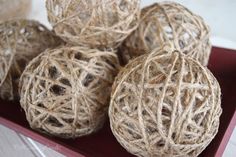 several balls of twine are sitting on a red tray