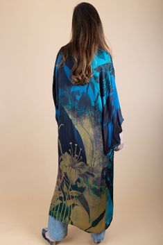 Our Vibrant Satin Kimono with abstract detailing features traditional kimono sleeves with modern floral motifs for a dash of electric flair. These polychromatic designs fill this flowy, relaxed kimono to give equal parts style and comfort. Style our kimono with a dress or casual outfit to indulge in a silky sensation all summer. Material: 100% Viscose Satin Length From HSP To Hem: 53.5" Sleeve Length: 13" Armhole Straight: 13.5" Shoulder Seam Length: 24.5" Bust 2.5 cm Below Underarm: 24" Made In Elegant Blue Floral Print Kimono, Spring Kimono With Abstract Print, Blue Printed Silk Kimono, Blue Floral Print Kimono, Blue Floral Print Flowy Kimono, Spring Silk Kaftan With Abstract Print, Flowy Blue Floral Print Kimono, Blue Flowy Long Kimono, Blue Silk Long Sleeve Kimono