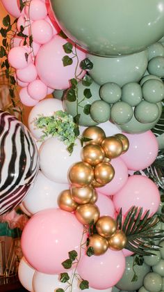 balloons, greenery and other decorations are arranged on the wall for an elegant party